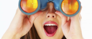 young girl looking-through-binoculars-at-the-beach